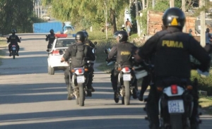 Fotografía de una calle en la que se ven policías de espalda en motos.