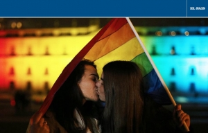 Pareja besándose con bandera del orgullo LGBTQI detrás. Imagen de El País.