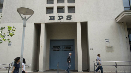 fotografia de la puerta del banco de previsión social en Montevideo, con personas circulando