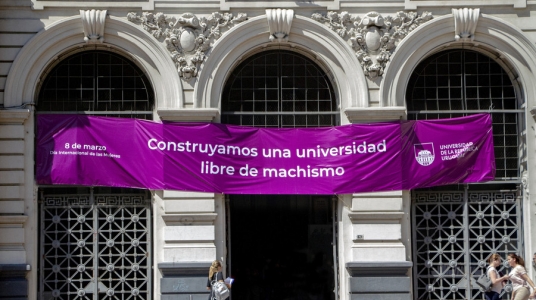 Fotografía del edificio central de la Universidad con una pancarta de color violeta. En ella, la inscripción: "Construyamos una Universidad libre de machismo"