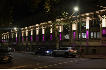 Fachada del edificio central de la Facultad de Psicología iluminada de color violeta