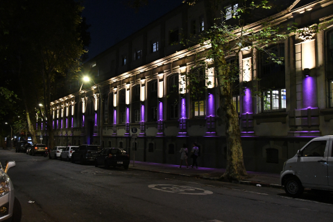 Fachada del edificio central de la Facultad de Psicología iluminada de color violeta