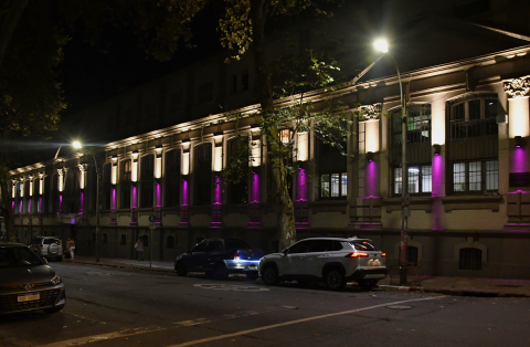 Fachada del edificio central de la Facultad de Psicología iluminada de color violeta