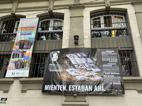 Fotografía de la fachada del edificio central de la Facultad con mural del proyecto fotográfico Imágenes del Silencio