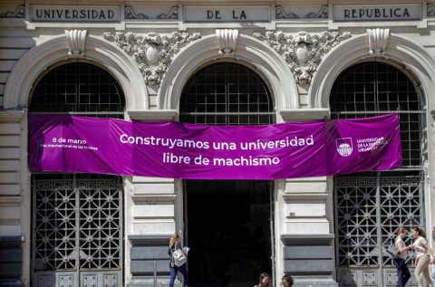 Fotografía del edificio central de la Universidad con una pancarta de color violeta. En ella, la inscripción: "Construyamos una Universidad libre de machismo"